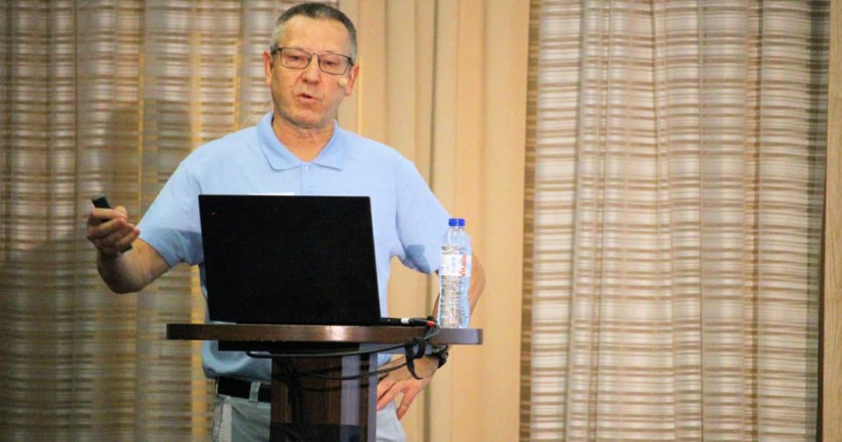 Morten Kromberg presenting at Dyalog '22 in Olhão, Portugal, outlining the roadmap of activity at Dyalog while standing at a podium with a laptop and a bottle of water.
