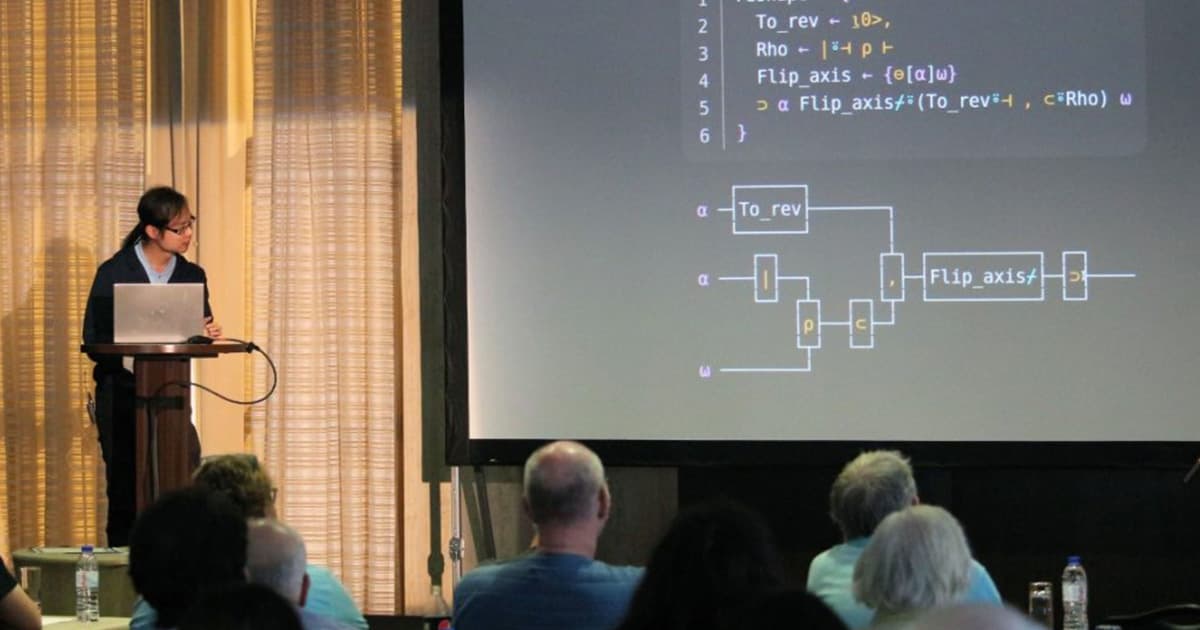 Student winner Tzu-Ching Lee presenting at Dyalog '22 in Olhão, Portugal, showcasing his winning solutions to the APL Problem Solving Competition with a projected slide displaying APL code and a visual diagram.