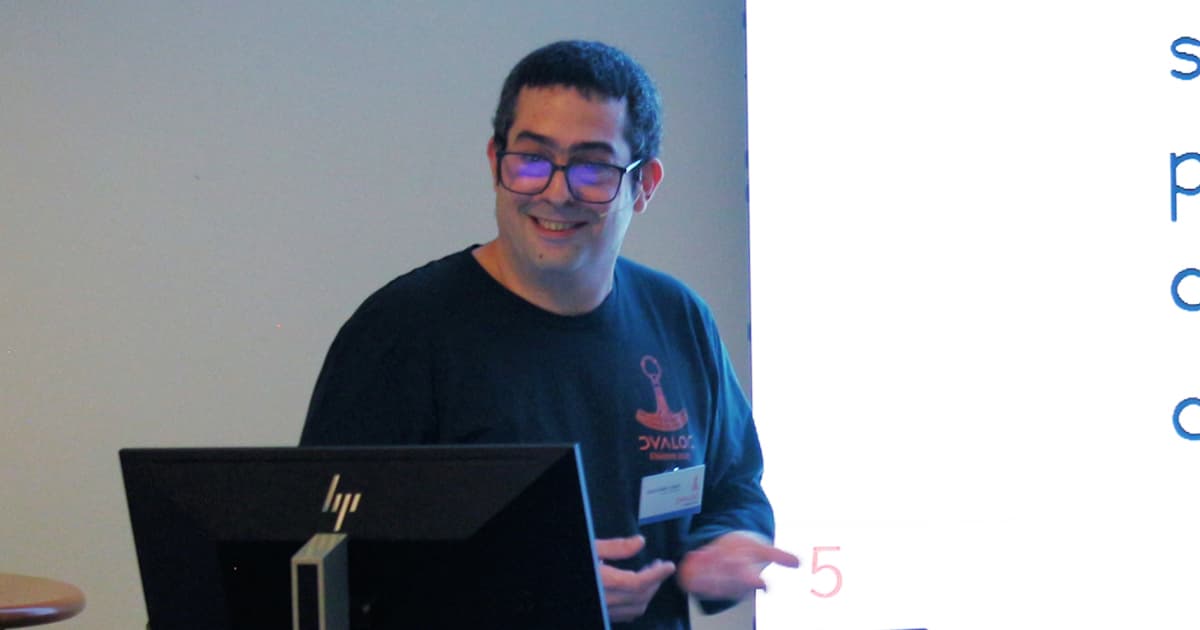 Jesús Galán López presenting at Dyalog ’24, standing beside a screen while explaining concepts related to using APL in data science.