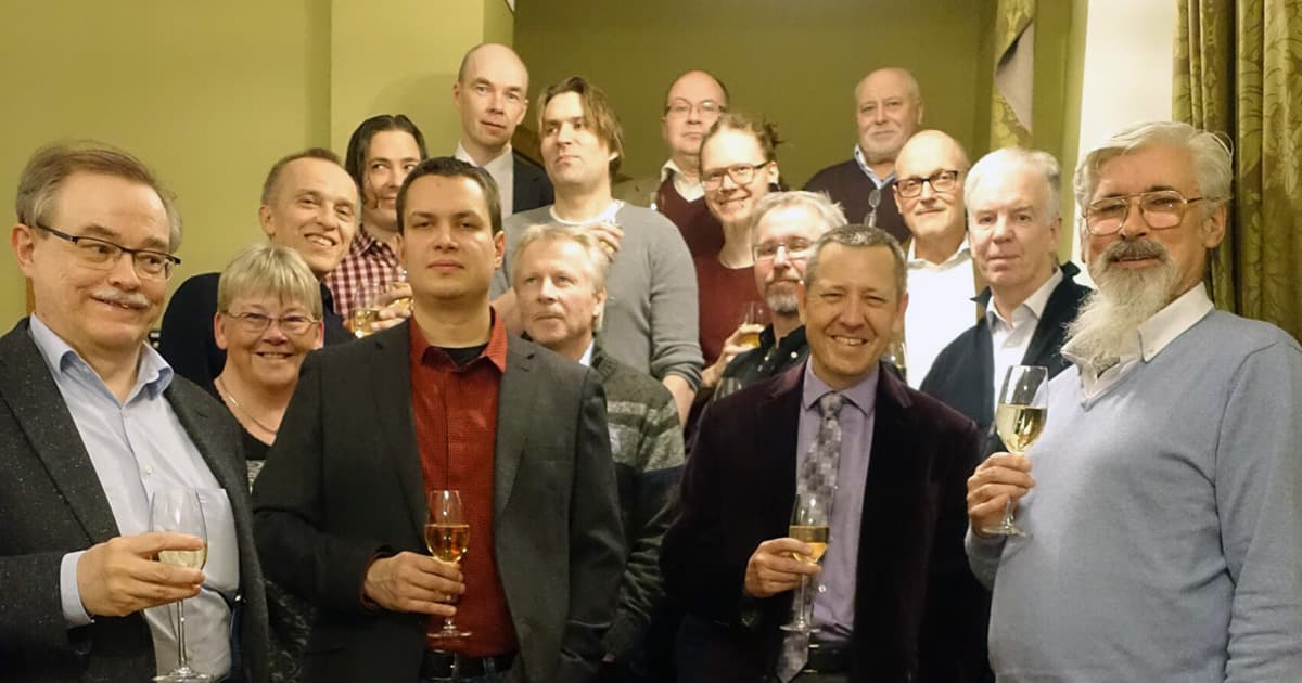 Group photo of attendees at the FinnAPL Forest Seminar 2016, gathered indoors and smiling with glasses of wine in hand.