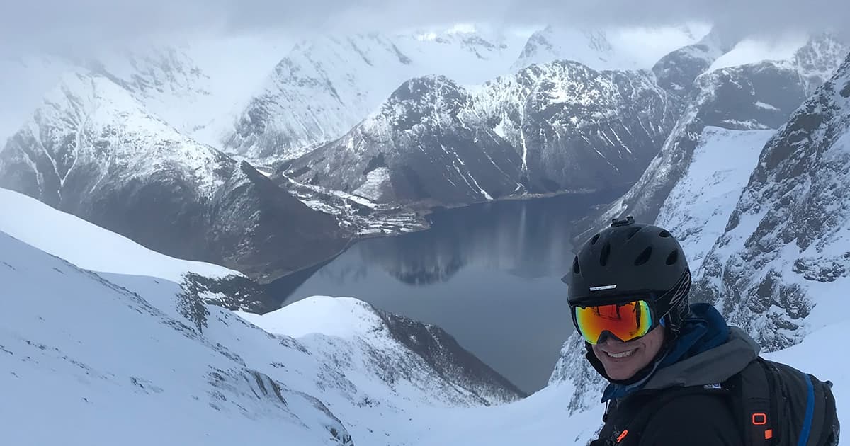 Stefan Kruger about to ski down a snow-covered slope in Norway’s Sunnmøre Alps, with dramatic fjords and mountains in the background.