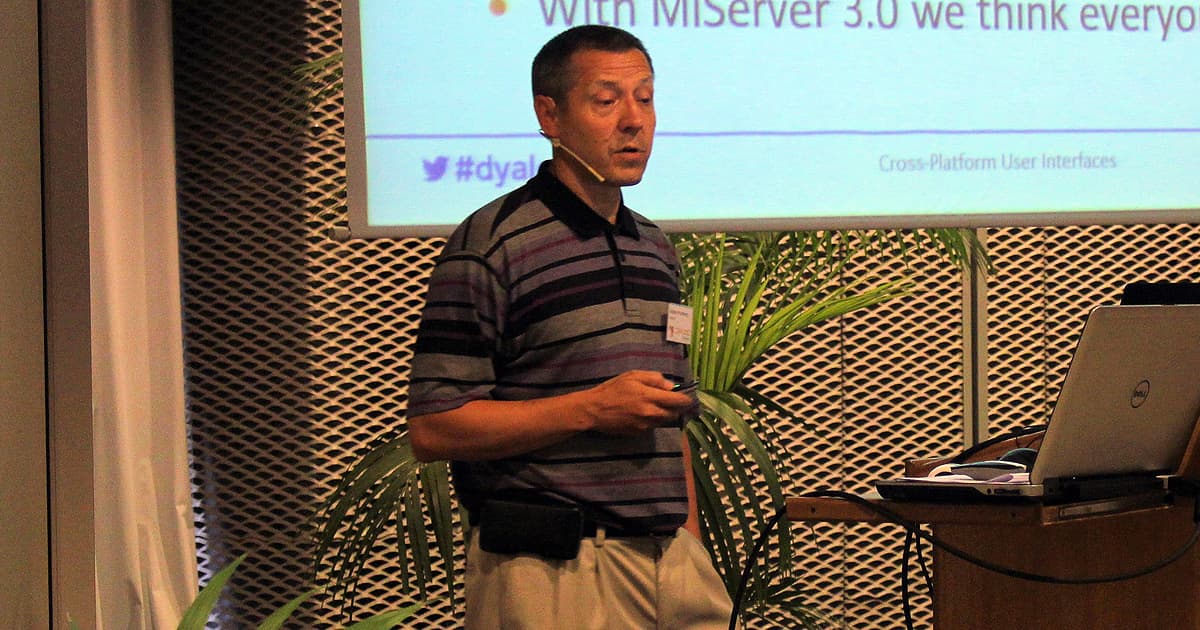 Morten Kromberg, in a striped shirt, presenting on MiServer 3.0 during Dyalog ’15 in Sicily, standing beside a laptop and projection screen.