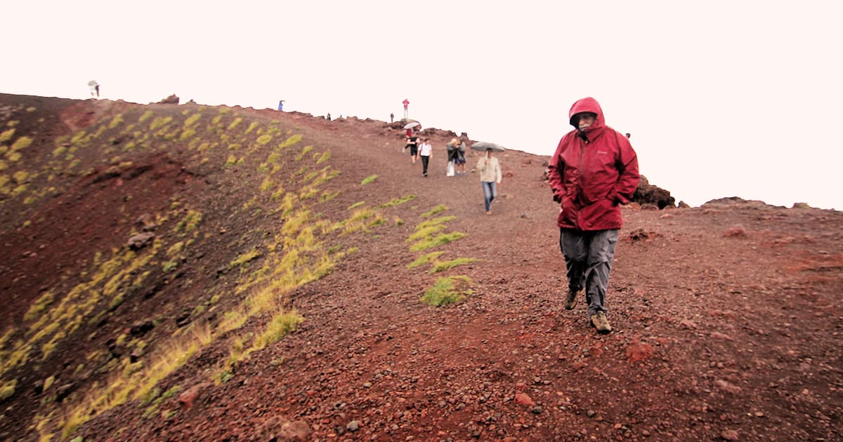 Geoff Streeter walking in the foreground on a volcanic slope during a group excursion at Dyalog '15 in Sicily.